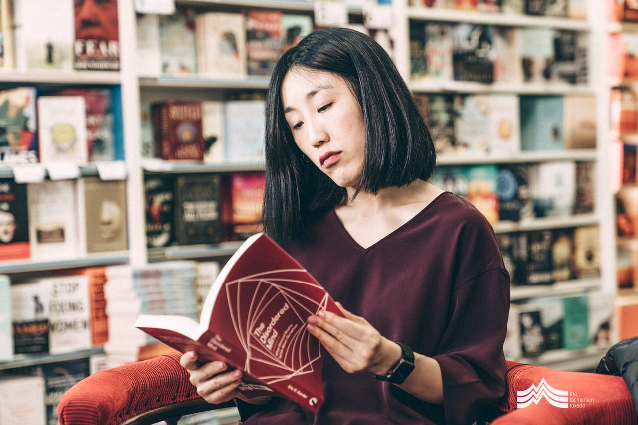 Suzie Han reading the book A Disordered Mind, Fullers Bookshop, Hobart Tasmania