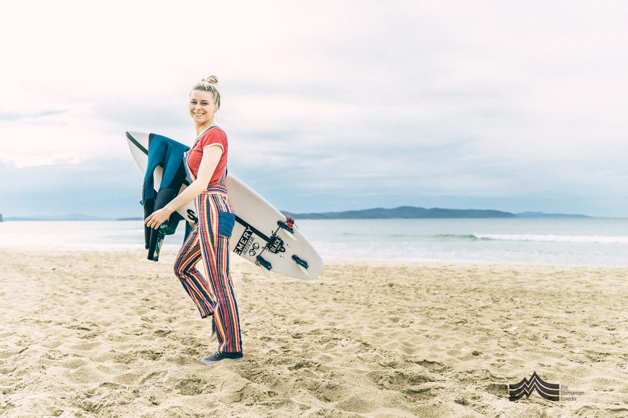 Brooke Mason walking on beach with surfboards