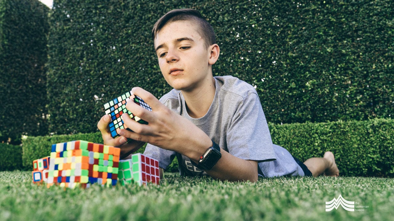 George Pelham laying on the grass with a rubiks cube